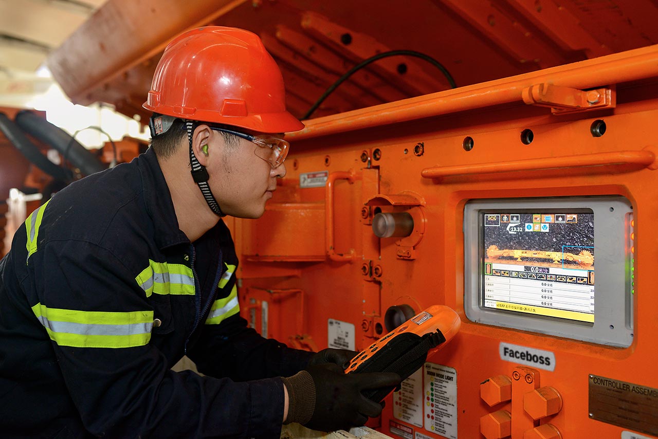 Miner looking at Faceboss screen on Joy shearer