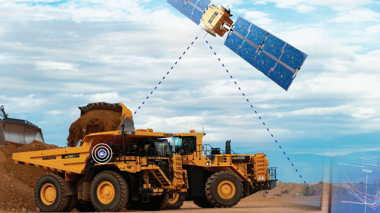 An illustration showing Komatsu mining truck connected to a satellite in the sky.